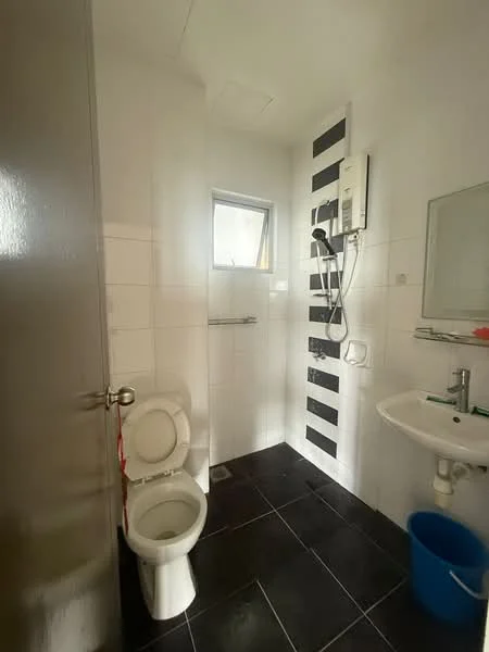 Bathroom features: white tiled walls, black tiled flooring, single-sink vanity with chrome faucet, framed mirror, one-piece toilet, walk-in shower with glass partition, shower head, window for natural light, wall-mounted water heater, towel rack, blue plastic bucket; style: modern.