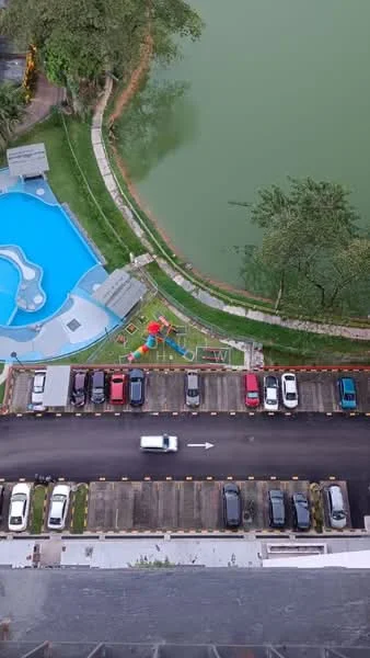 Exterior type: high-rise condominium; features: infinity pool, children's playground, landscaped garden, manicured lawn, parking lot with multiple vehicles, waterfront view, surrounding greenery; style: modern.