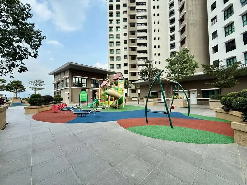 Exterior type: clubhouse; features: children's playground with slides and climbing structures, rubberized safety flooring in multiple colors, manicured landscaping with shrubs, paved walkway, seating areas, surrounding high-rise buildings, open space for recreational activities; style: modern.