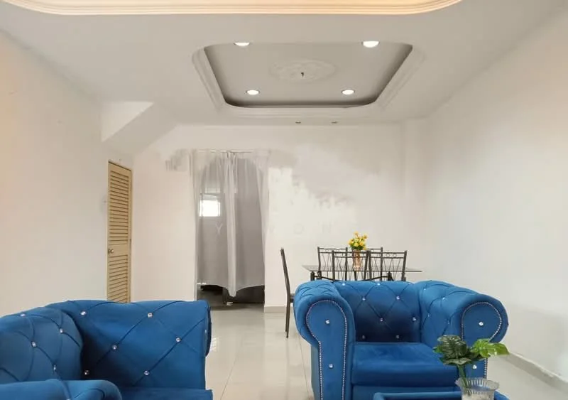 Living features: blue velvet sofa with diamond tufting, white painted walls, glossy tile flooring, tray ceiling with decorative molding, recessed downlights, ceiling rose, glass dining table with black chairs, decorative plant in ceramic pot, curtains, window with sheer treatment; style: modern.