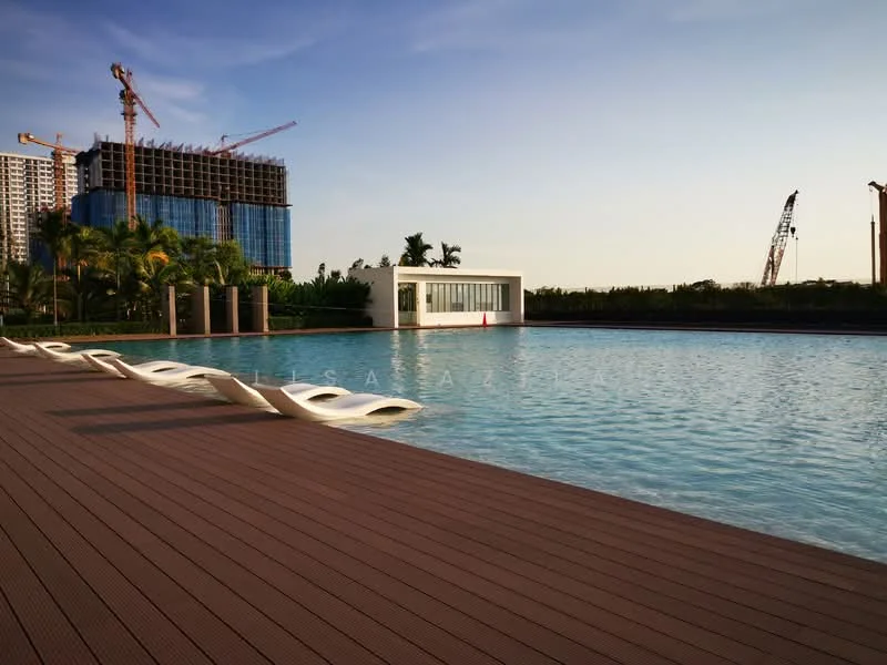 Exterior type: swimming pool deck; features: infinity pool, pool deck with loungers, surrounded by palm trees, landscaped area, modern pool house, construction cranes in background, manicured lawn, wooden decking; style: modern.