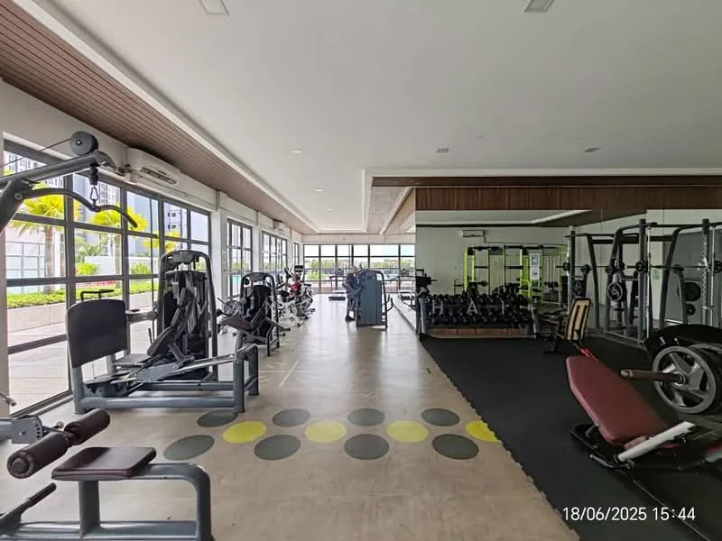 Room features: large windows with natural light, rubber flooring, weightlifting equipment, cardio machines, exercise mats, mirrored wall, wooden ceiling, open layout, fitness accessories, seating area; style: modern; view: garden.