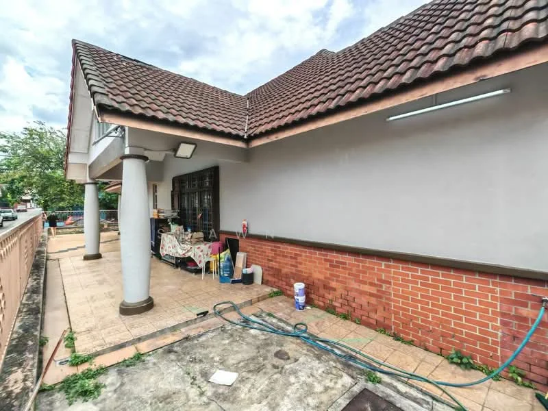 Exterior type: semi-detached house; features: red brick facade, cream painted walls, pitched tile roof, covered porch area, outdoor seating area, manicured lawn, paved walkway, exposed concrete flooring, outdoor lighting fixtures; style: modern.