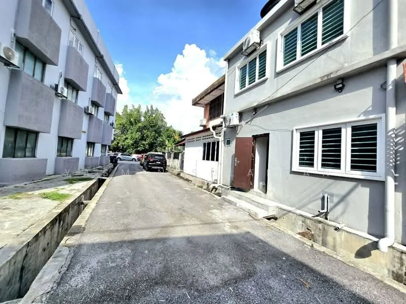 Exterior type: linked terrace house; features: grey painted facade, white window frames, asphalt driveway, 2-storey building, visible air conditioning units, paved walkway, surrounded by greenery, car parking space, clear blue sky; style: modern.