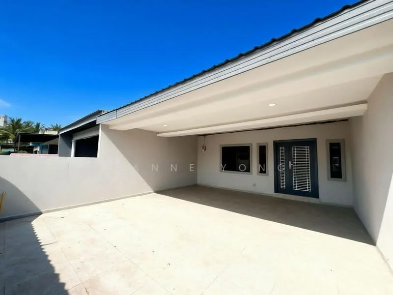 Exterior features: flat roof, cream painted facade, large overhang, outdoor patio area, tile flooring, exterior wall with windows, sliding glass door, light fixtures, clear blue sky; style: modern.