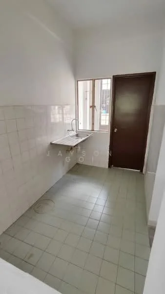 Room features: white painted walls, light grey floor tiles, single-bowl stainless-steel sink, chrome pull-down faucet, window with grid pattern, brown wooden door, tile backsplash, no visible cabinetry.