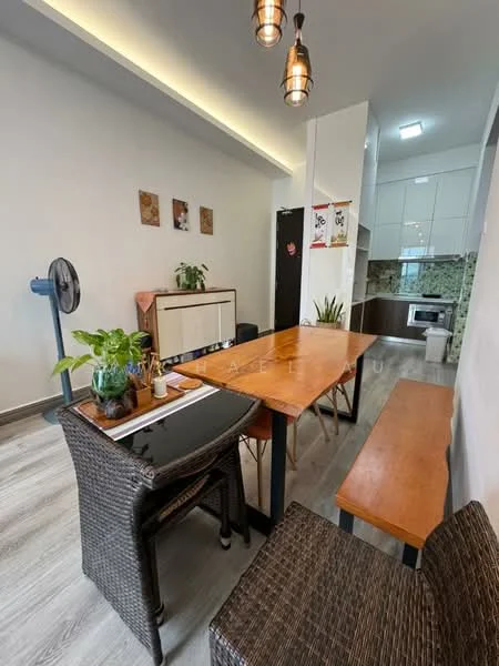 Dining features: wood dining table, 4 wicker dining chairs, green potted plant on table, wall-mounted fan, light wood flooring, white painted walls, recessed ceiling lights, kitchen area visible in background, kitchen cabinets with green backsplash, microwave visible in kitchen; style: modern.