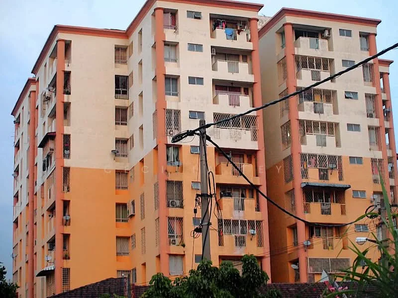Exterior type: mid-rise condominium; features: orange painted facade, cream painted facade, balconies with metal railings, multiple storeys, visible laundry hanging on balconies, power lines in foreground, surrounded by greenery; style: modern.