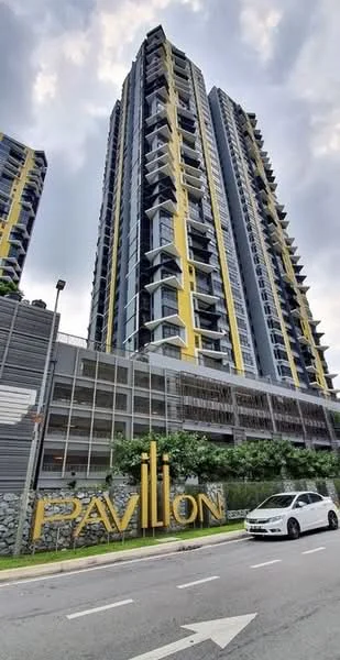 Exterior type: high-rise condominium; features: glass curtain wall, yellow and grey facade, recessed balconies, multiple storeys, landscaped area with greenery, parking structure visible, prominent building signage, urban street view; style: modern.