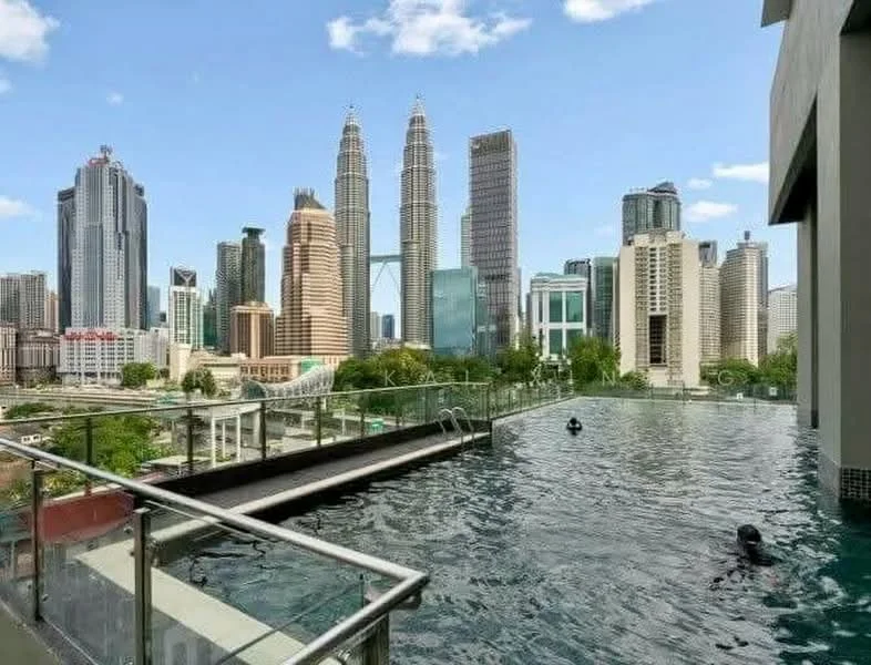 Exterior type: high-rise condominium; features: infinity pool, pool deck with loungers, city skyline view, glass railing, surrounded by greenery, modern architecture; style: modern.