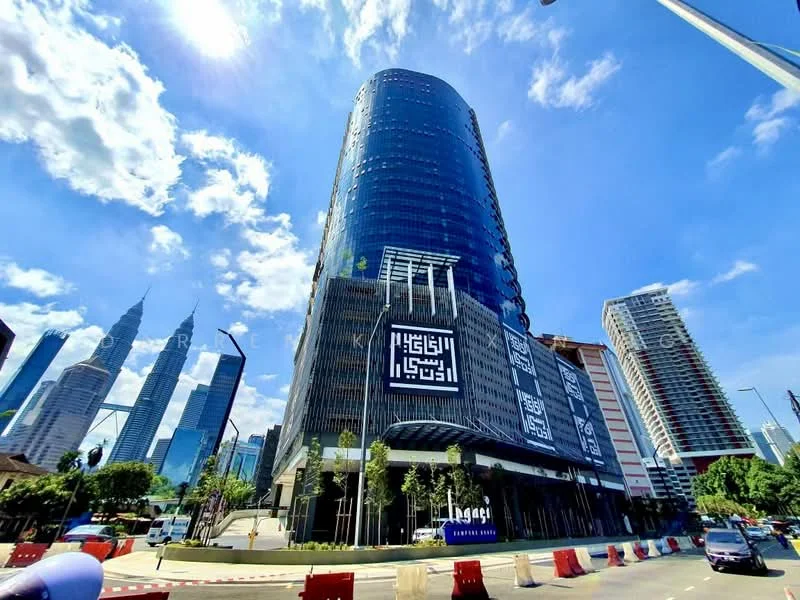 Exterior type: high-rise condominium; features: glass curtain wall, projecting balconies, feature lighting at night, manicured landscaping, surrounded by mature greenery, urban context with city skyline, adjacent to main road; style: modern.