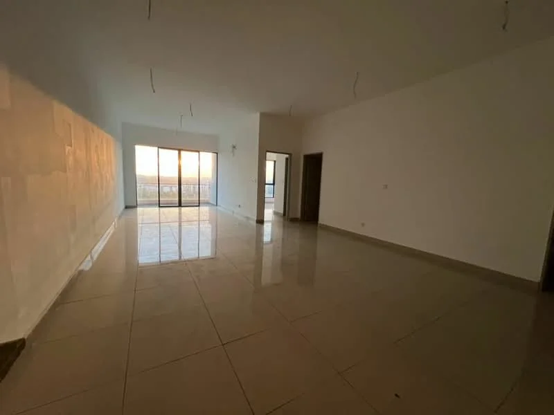 Living features: white painted walls, glossy ceramic tile flooring, floor-to-ceiling sliding glass door, natural light from large windows, neutral color scheme, minimalist design, no visible furniture, smooth ceiling with no visible fixtures; style: modern; view: city.