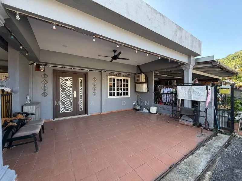 Exterior type: linked terrace house; features: grey painted facade, flat roof, porch area with tiled flooring, ceiling fan, decorative wall with geometric pattern, window with grille, air conditioning unit, clothes drying area, outdoor seating area with chairs, string lights; style: modern.