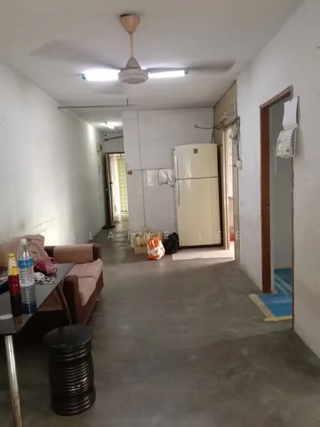 Room features: grey concrete flooring, white painted walls, ceiling fan, refrigerator, sofa, coffee table, doorway leading to another room, light fixtures on ceiling, window with natural light, plastic water bottles, plastic bags, telephone intercom; style: minimalist.
