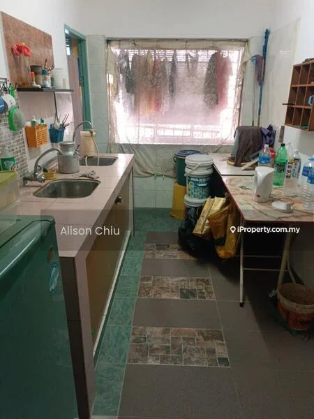 Kitchen features: single-bowl stainless-steel sink, chrome pull-down faucet, laminate countertop, green cabinetry, built-in shelves, ceramic tile flooring, wall-mounted storage, table with chairs, buckets and cleaning supplies, clothes drying rack, window with sheer curtains.