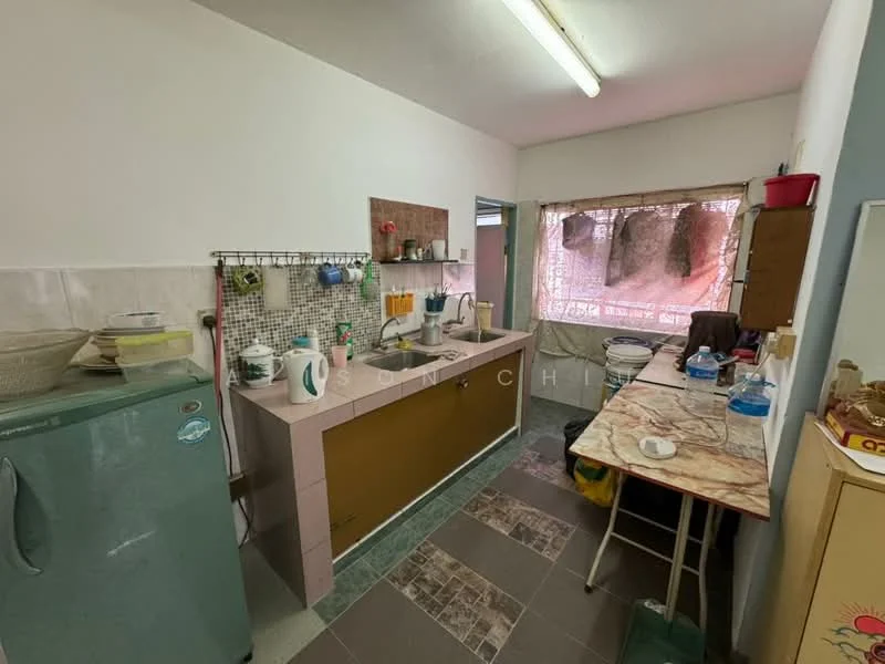 Kitchen features: single-bowl stainless-steel sink, chrome pull-down faucet, pink countertop, mosaic tile backsplash, green cabinetry, white painted walls, tile flooring, refrigerator, kitchen table with marble top, open shelving, window with sheer curtains, wall-mounted light fixture.
