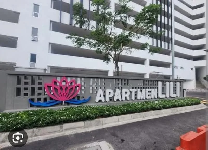 Exterior type: low-rise apartment block; features: white painted facade, landscaped garden with shrubs, signage with pink lotus design, paved driveway, parking spaces, surrounding greenery; style: modern.
