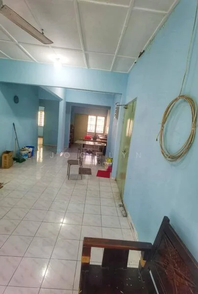 Room features: light blue painted walls, white tiled flooring, ceiling with fluorescent lights, open layout, multiple doorways, windows with natural light, furniture including a wooden bench, visible dining area in the background.