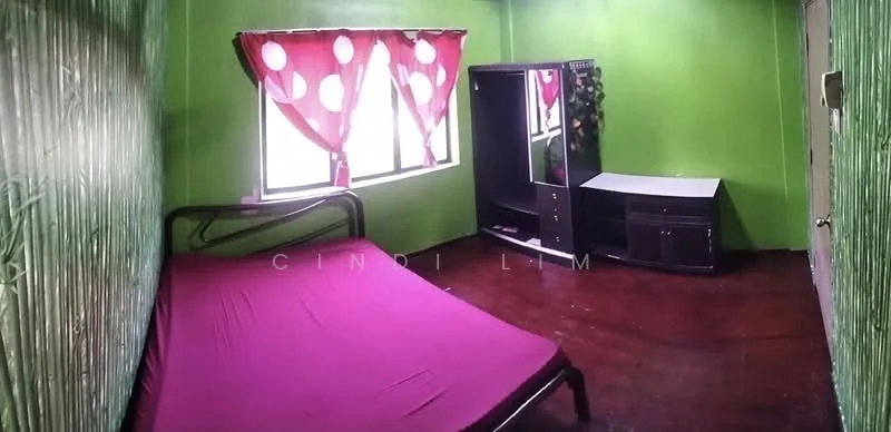 Bedroom features: green painted walls, wood flooring, single bed with purple bedspread, curtains with polka dots, wardrobe with mirror, TV console, decorative plant, window with natural light.