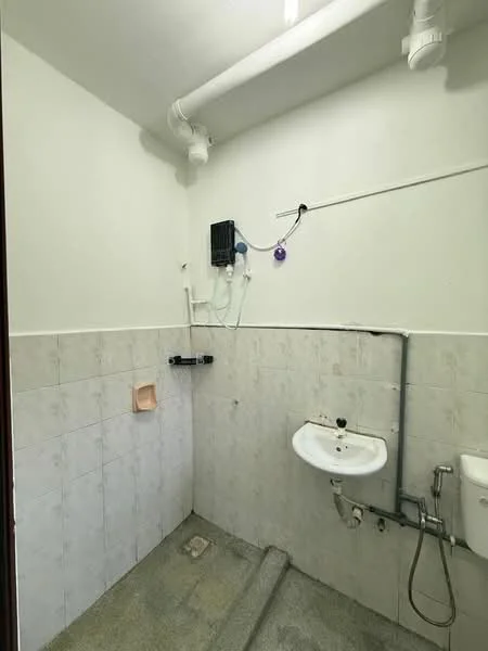 Laundry features: white painted walls, grey tiled flooring, single-bowl sink, wall-mounted water heater, exposed plumbing, drainage outlet, step-up access, light fixture on ceiling.