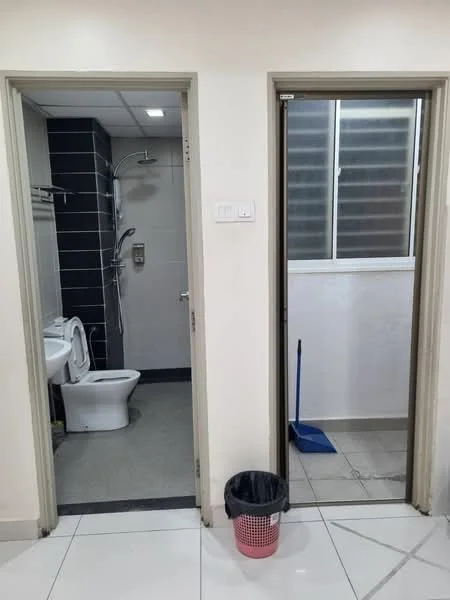 Bathroom features: white toilet, shower with glass partition, chrome shower head, grey tile flooring, black accent wall, towel rack, sink with chrome faucet, mirror above sink; style: modern. Laundry features: grey tile flooring, window with horizontal slats, broom, trash bin.