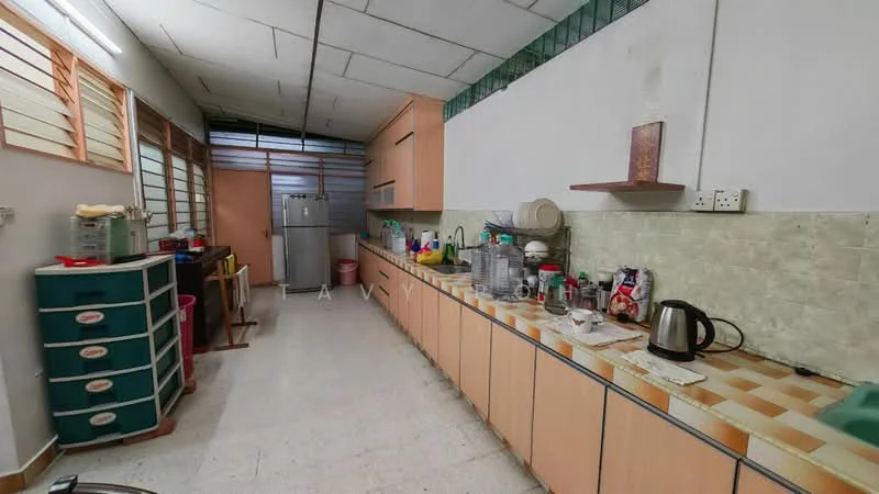 Kitchen features: light green tiled backsplash, laminate countertop, wood cabinetry in light brown, stainless-steel fridge, kettle, various kitchen utensils, sink, plastic storage containers, floor tiles, multiple windows for natural light, open shelving, plastic bins, countertop with clutter.