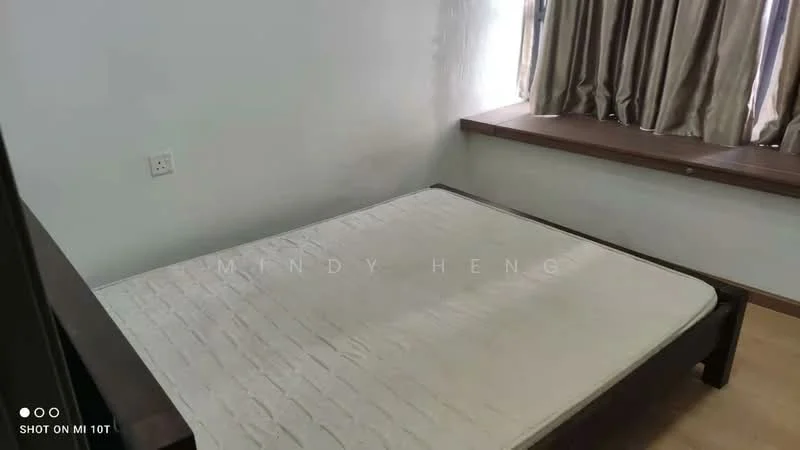 Bedroom features: wooden bed frame, mattress on bed, light-colored walls, window with curtains, wooden window sill, laminate flooring, power outlet on wall.