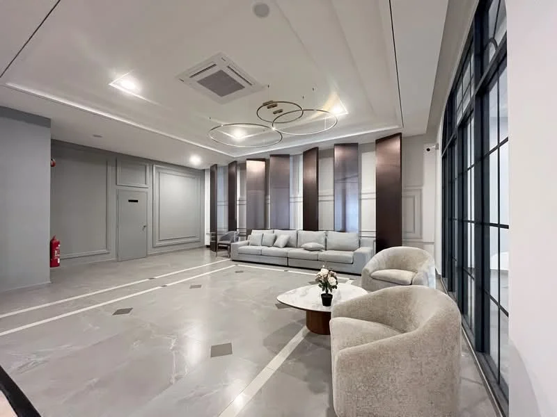 Living features: grey marble flooring, white painted walls, tray ceiling with recessed lighting, large floor-to-ceiling windows, modern 3-seater fabric sofa in light grey, round wooden coffee table, two beige accent chairs, decorative flower arrangement on table, ceiling-mounted air conditioning unit, wall-mounted fire extinguisher; style: modern.