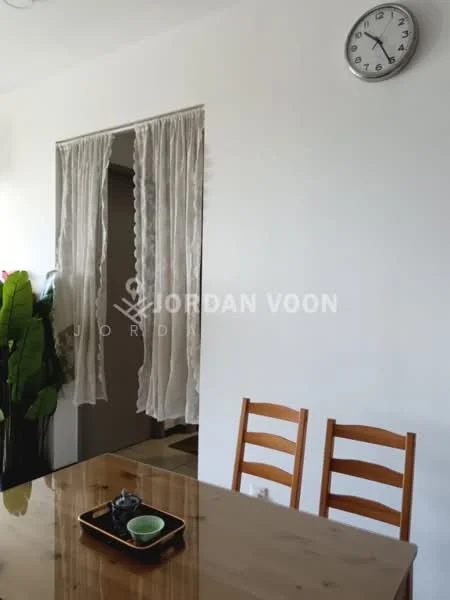 Dining features: wooden dining table, two wooden chairs, white painted walls, curtains, wall clock, indoor plant, flooring not visible; style: minimalist. Room features: doorway leading to another room, flooring not visible.