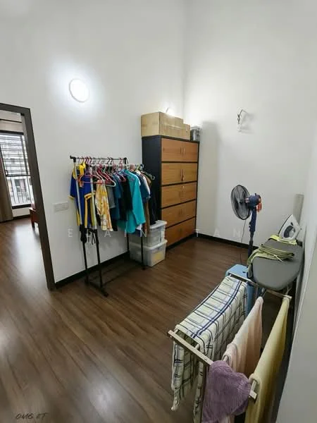 Room features: light wood laminate flooring, white painted walls, ceiling light fixture, built-in wardrobe with multiple drawers, clothes rack with hanging clothes, folding drying rack with clothes, standing fan, storage boxes on top of wardrobe; style: modern.