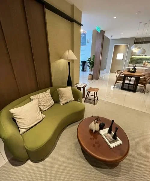 Living features: curved green sofa, two decorative pillows, wooden coffee table, area rug, floor lamp, wall paneling with wood accents, recessed ceiling lights, dining area visible in background, neutral wall color, ceramic tile flooring; style: modern.