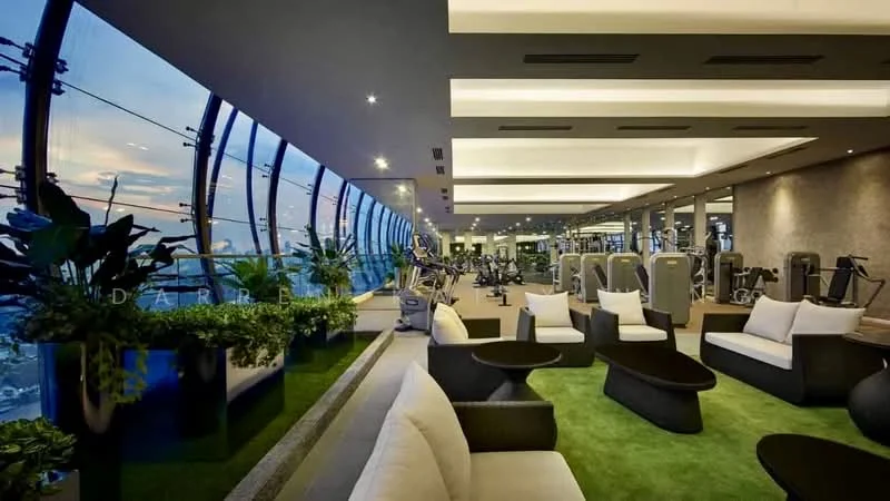Room features: floor-to-ceiling windows, greenery planters, artificial grass flooring, modern lounge seating, recessed downlights, open layout, gym equipment visible, contemporary decor; style: modern; view: city.