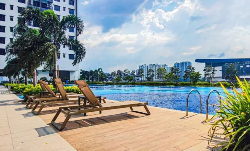 Exterior type: high-rise condominium; features: infinity pool, pool deck with loungers, landscaped garden with greenery, palm trees, surrounding city skyline, modern architecture, manicured lawn; style: modern.