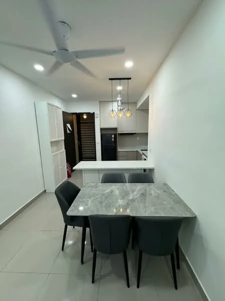 Dining features: 4-seater dining table with marble top, upholstered dining chairs in grey, pendant lighting with three bulbs, white painted walls, recessed LED downlights, grey tiled flooring, open kitchen layout visible in background, ceiling fan; style: modern. Kitchen features: white cabinetry, stainless-steel fridge visible in background, countertop with white surface, open layout to dining area; style: modern.