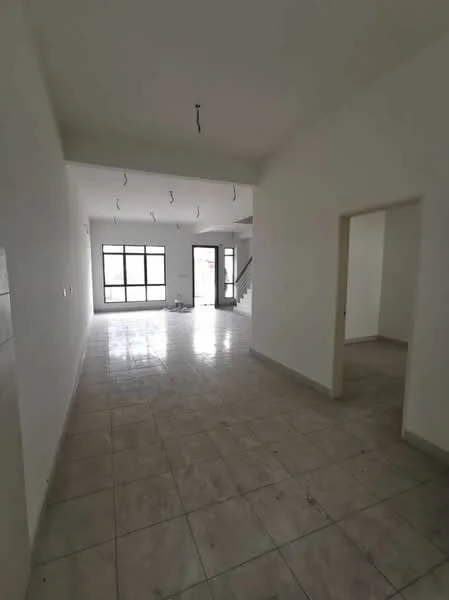 Room features: white painted walls, tile flooring, large windows, doorway leading to another room, staircase visible in background, ceiling with exposed wiring, open layout, natural light from windows.