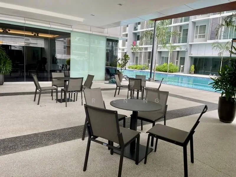 Exterior type: clubhouse; features: outdoor seating area, glass walls, swimming pool visible in background, manicured landscaping, potted plants, concrete flooring, tables with chairs, sunny environment; style: modern.