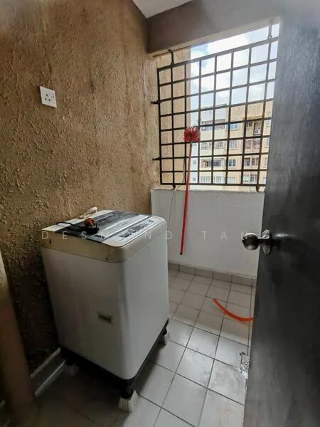 Laundry features: washing machine, grey tiled flooring, exposed concrete walls, window with metal grille, light fixture, red cleaning tool, drainage area.