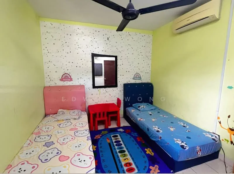 Bedroom features: two single beds with pink and blue headboards, colorful bedding with cartoon patterns, small red plastic table and chair, ceiling fan, wall-mounted air conditioning unit, light green painted walls, decorative wall with polka dots, carpet with animal designs, white tiled flooring, framed mirror on the wall; style: child-friendly.