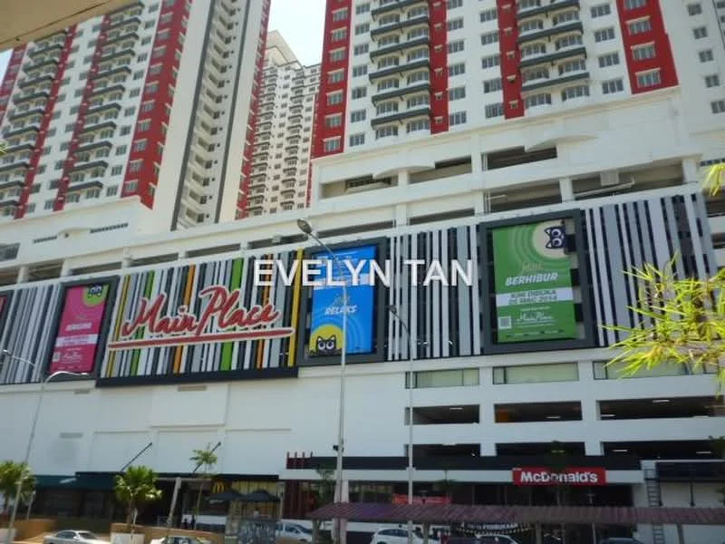 Exterior type: mid-rise condominium; features: multi-storey building, red and white painted facade, commercial signage, ground-level retail spaces, visible McDonald's outlet, decorative vertical stripes on facade, balconies on upper floors, surrounded by urban landscape; style: modern.
