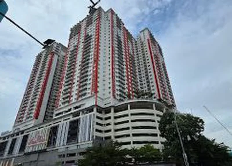Exterior type: high-rise condominium; features: red and white painted facade, glass curtain wall, multiple balconies, approximately 30-storey high-rise, parking deck at base, surrounded by greenery, urban context with nearby roads; style: modern.