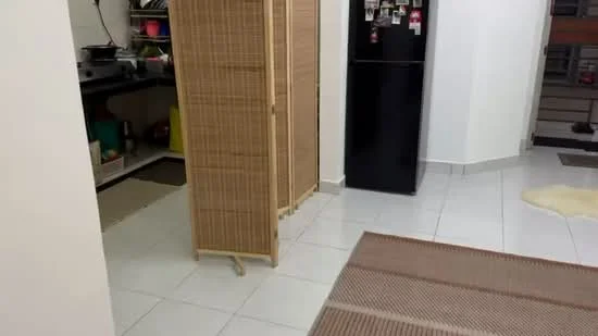 Room features: white painted walls, white tiled flooring, black refrigerator, bamboo room divider, area rug, open shelving, kitchen counter, visible kitchen appliances.