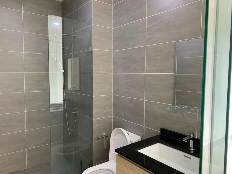 Bathroom features: grey tile walls, black countertop, single-sink vanity with wood cabinet, chrome basin mixer faucet, one-piece toilet, walk-in shower with glass enclosure, rain shower head, handheld shower, mirror, recessed lighting; style: modern.