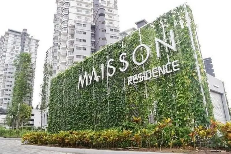Exterior type: high-rise condominium; features: green wall with climbing plants, modern signage with 'MAISSON RESIDENCE', surrounding landscaping with shrubs, paved walkway, multiple high-rise buildings in background, manicured garden area; style: modern.
