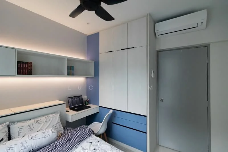 Bedroom features: queen-size bed with patterned bedding, built-in wardrobe with white cabinetry, study desk with chair, wall-mounted air conditioning unit, light blue accent wall, shelves above the bed, recessed lighting, ceiling fan; style: modern.