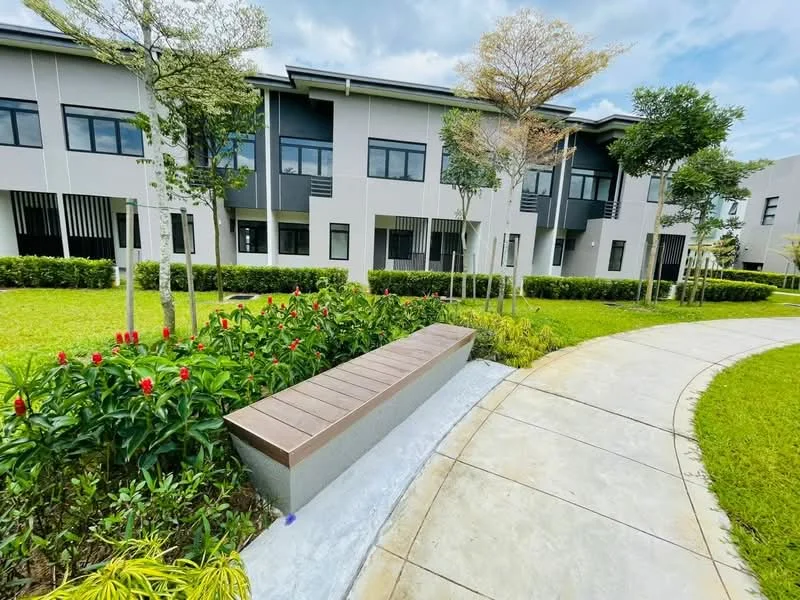 Exterior type: low-rise apartment block; features: manicured lawn, flower beds with red flowers, pathway with curved design, benches, trees, modern facade, multiple windows, green landscaping; style: modern.