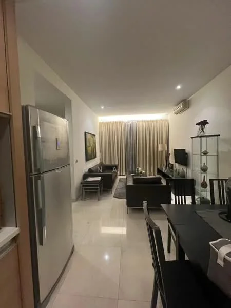 Living features: marble tile flooring, white painted walls, recessed downlights, sofa in black leather, coffee table, TV console, wall-mounted TV, floor-to-ceiling windows with sheer curtains, decorative display cabinet, area rug with geometric pattern, air conditioning unit; style: modern. Kitchen features: stainless-steel fridge, wood cabinetry, countertop with breakfast bar, open shelving; style: modern.