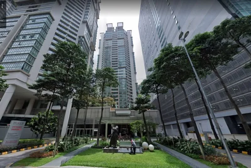 Exterior type: high-rise condominium; features: glass curtain wall, concrete facade, landscaped garden with greenery, manicured lawn, sculpture in garden, paved walkway, surrounded by tall buildings, multiple storeys, outdoor lighting, trees lining the walkway; style: modern.