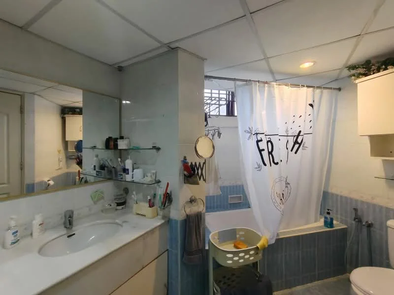 Bathroom features: single-sink vanity with marble top, chrome basin mixer faucet, framed mirror, bathtub with shower curtain, white shower curtain with graphic design, wall-mounted storage shelves, blue tiled walls, white ceiling, recessed lighting, tiled flooring, toilet, laundry basket; style: modern.