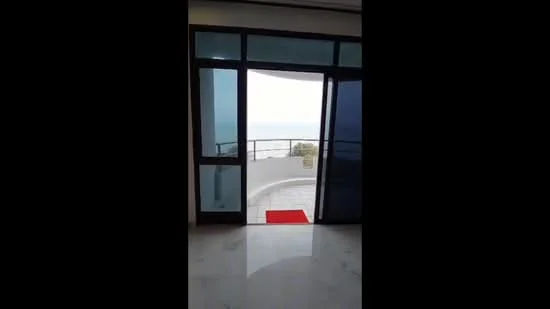 Room features: marble flooring, sliding glass door, floor-to-ceiling windows, red outdoor mat, white walls, balcony view; view: sea.