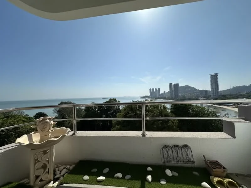 Room features: balcony with sea view, glass railing, artificial grass flooring, decorative stones, sculptural decor, city skyline view, surrounding greenery; style: modern; view: sea.